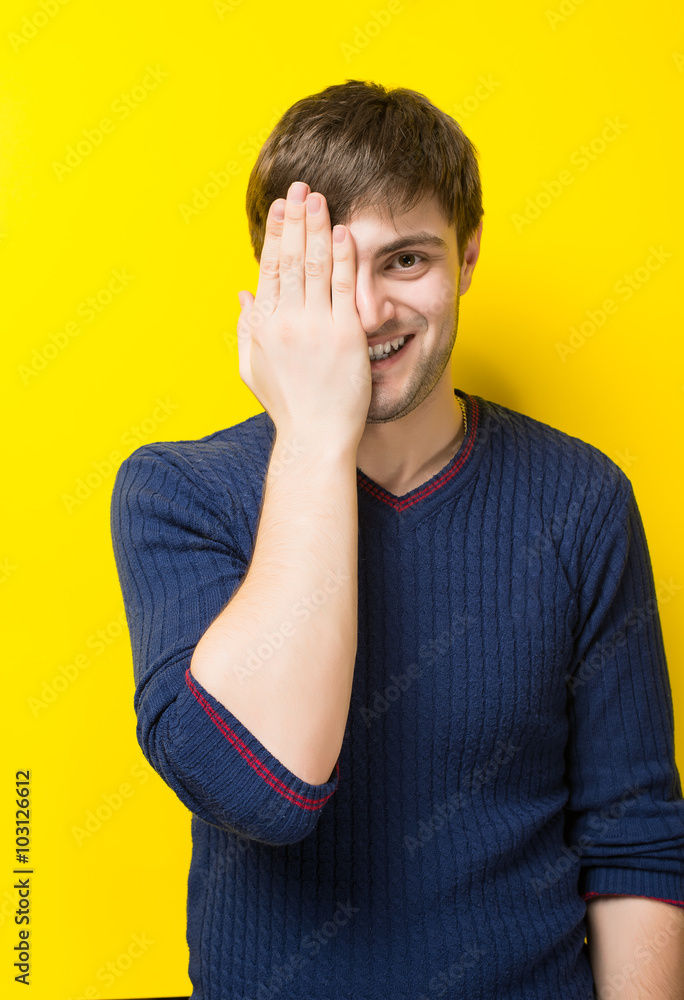 young man closed his eyes hand on a yellow background young man closed his eyes hand on a yellow background