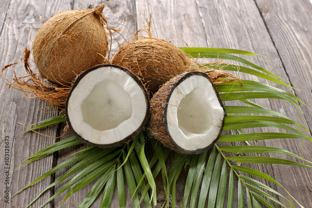 Coconuts with palm leaves on wooden background
Coconuts with palm leaves on wooden background