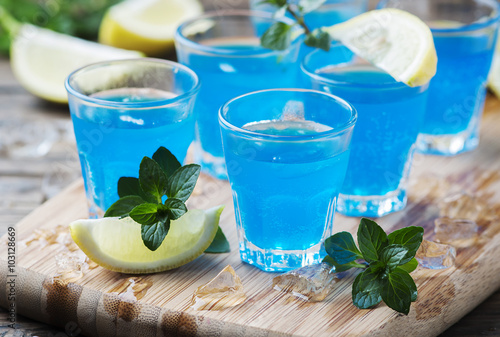 Foto Blue curacao liqueur with lemon on the wooden table