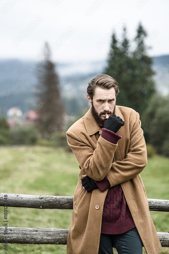Fototapeta premium man in a brown coat and torn trousers