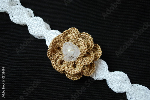 Fototapeta Naklejka Na Ścianę i Meble -  Crochet headband white with gold flower.