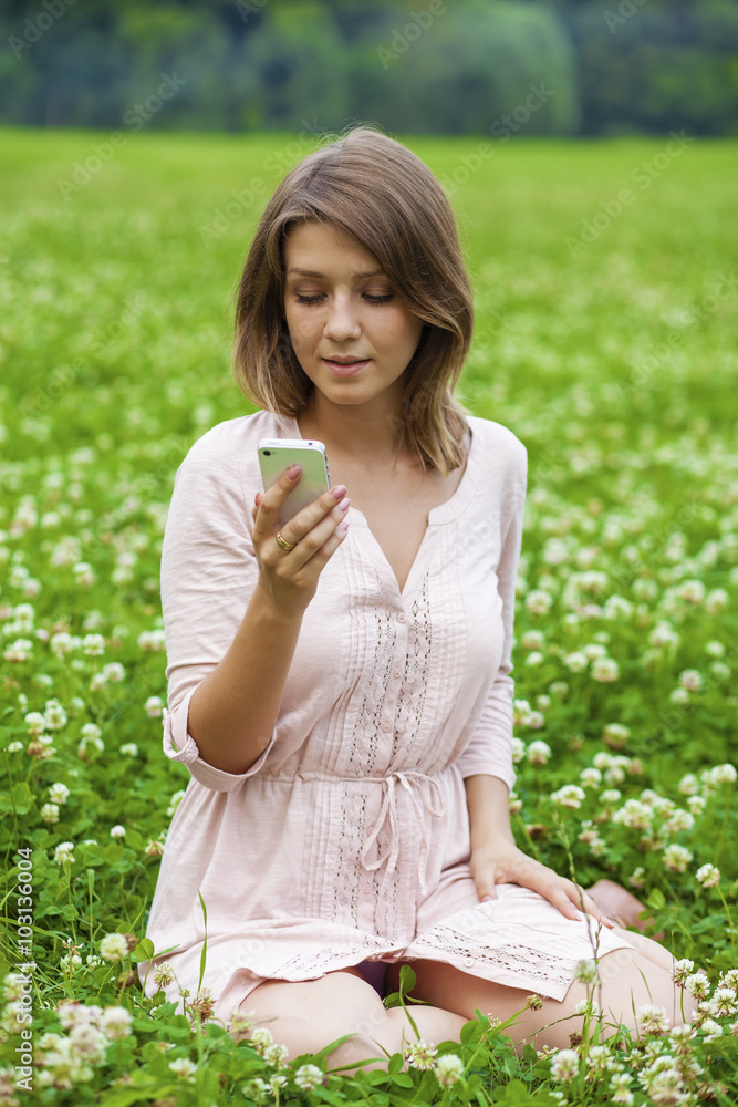 Young woman reading a message on the phone Young woman reading a message on the phone