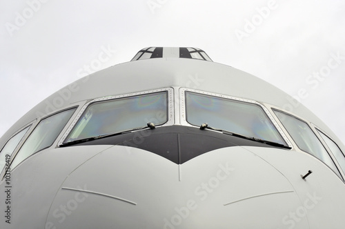 Front view close-up of a transportation airplane with cloudy sky 