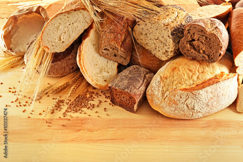 Assortment of fresh baked bread on the wooden background