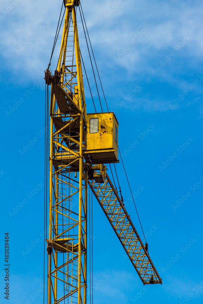 Yellow building crane under blue sky