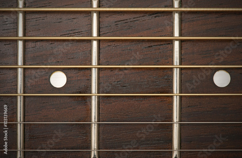 close-up macro of guitar strings and fret board
