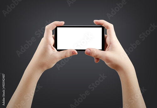 Two hands holding big screen smart phone, isolated on dark background, clipping path
