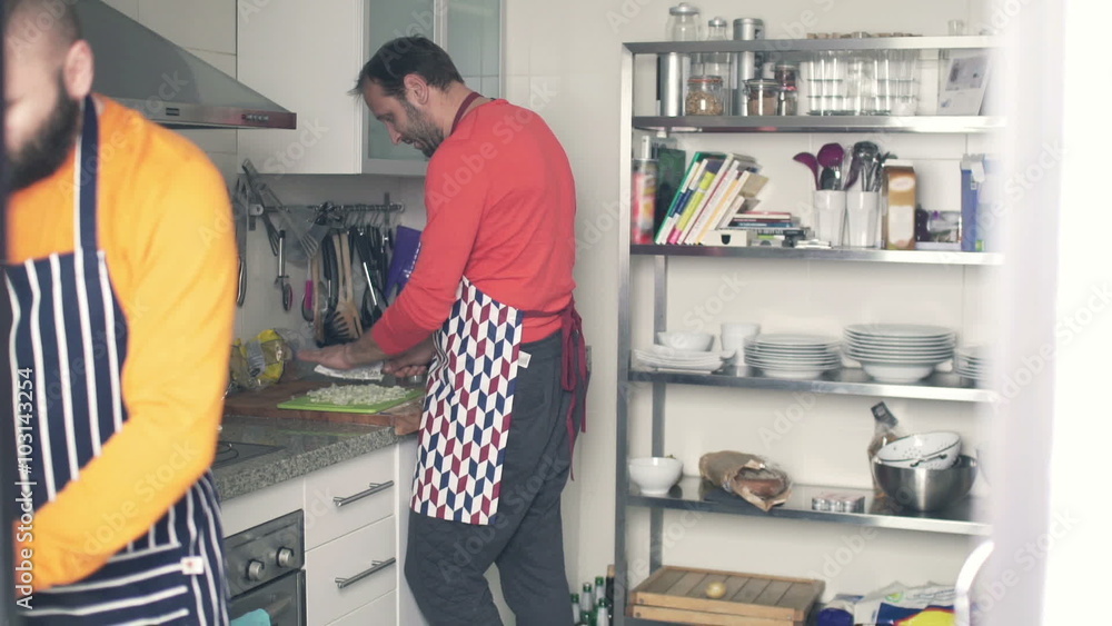 Two men in aprons cooking in the kitchen at home
Two men in aprons cooking in the kitchen at home
