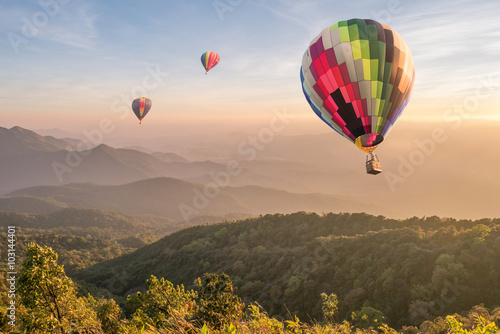 Hot air balloon above high mountain at sunset