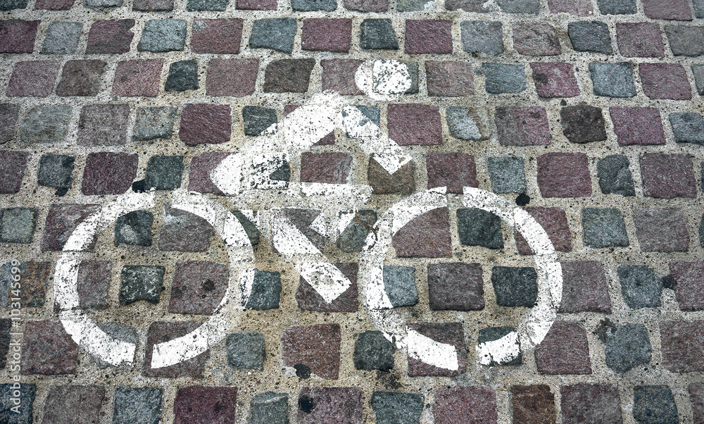Bike riding allowed sign painted on brick street Bike riding allowed sign painted on brick street