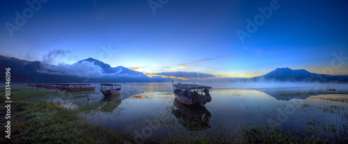 Boats wait for passengers. View of boats leaning on the lake in the early of the dawn in kintamani lake bali photo