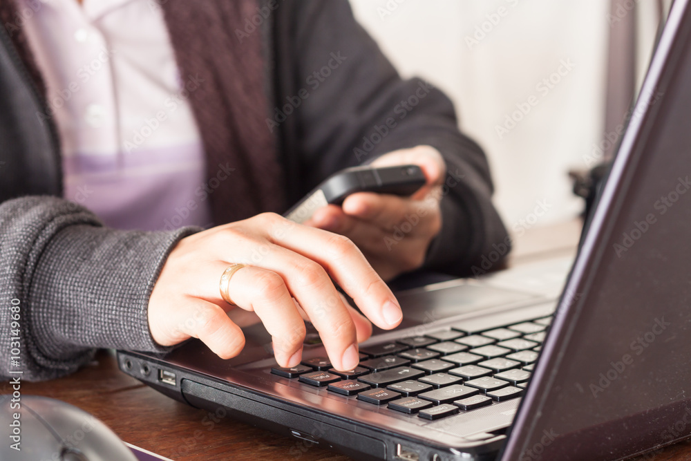 Woman using smart phone at office desk Woman using smart phone at office desk