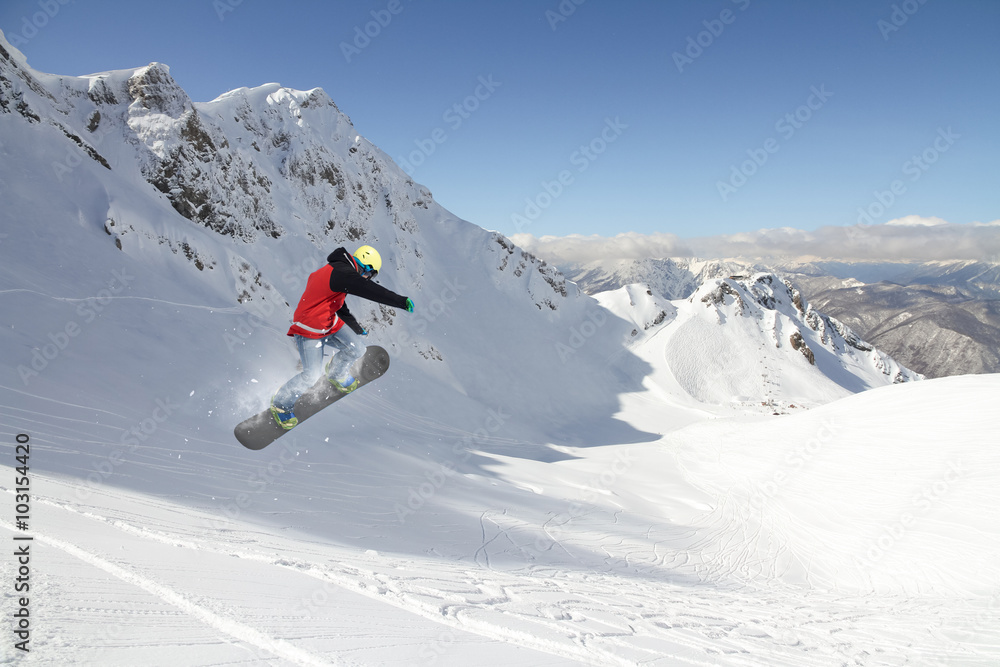 Flying snowboarder on mountains. Extreme sport.