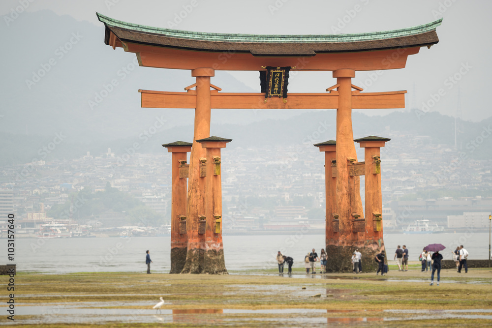 Miyajima, Floating Torii gate in Japan with blurred tourists.