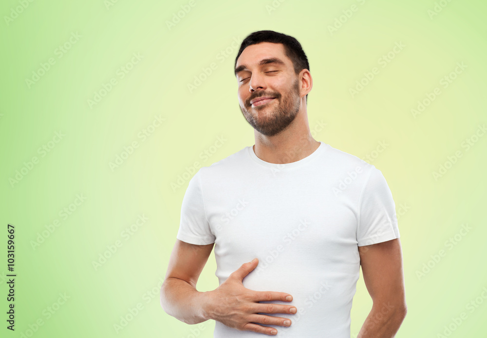 Obraz premium happy full man touching tummy over green 