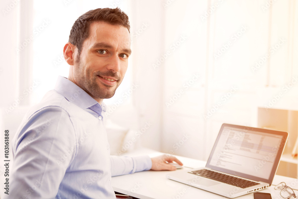 Young business man working at home on his laptop