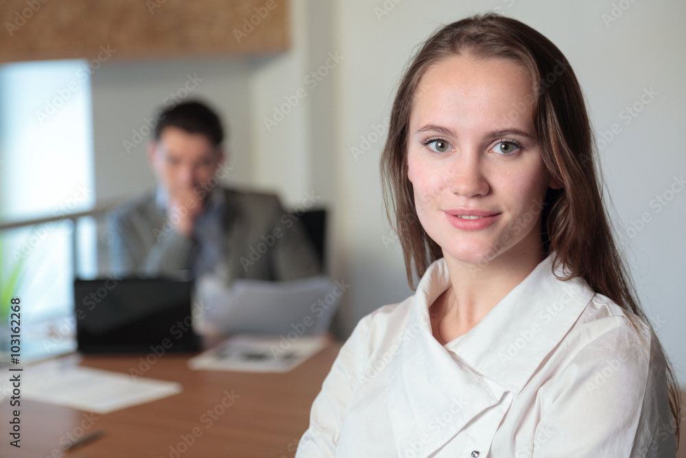 portrait of a girl in the office on the background of working at portrait of a girl in the office on the background of working at