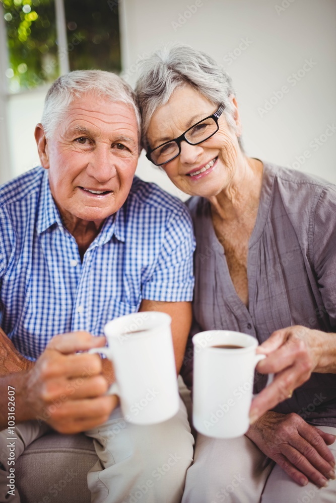 Senior couple having coffee in living room Senior couple having coffee in living room