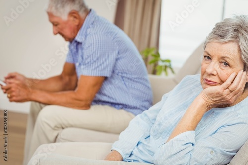 Worried senior woman sitting on sofa