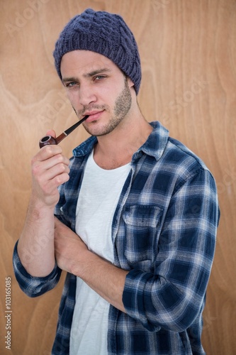 Handsome hipster smocking a pipe