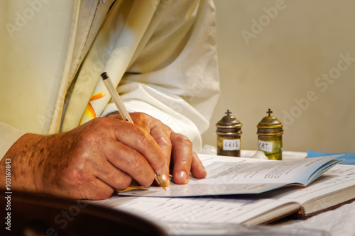 Priest signs the book of ceremonies photo