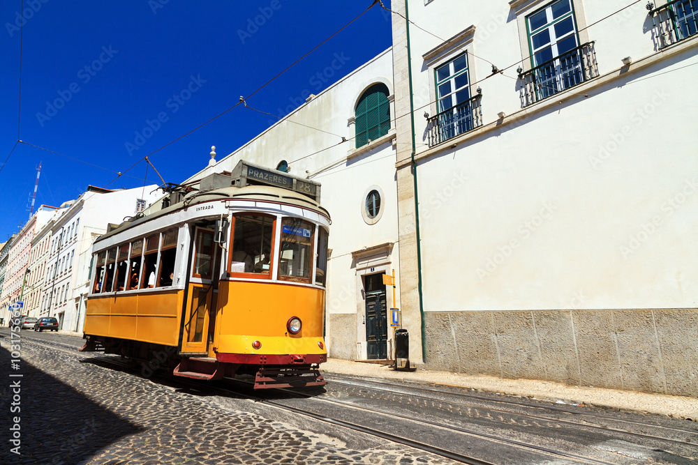 Beautiful traditional yellow tram in the streets of Lisbon, Portugal, in summer