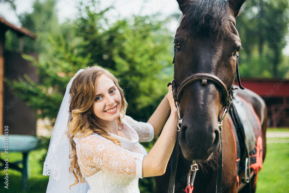 Fototapeta premium Beautiful bride and a horse in the park