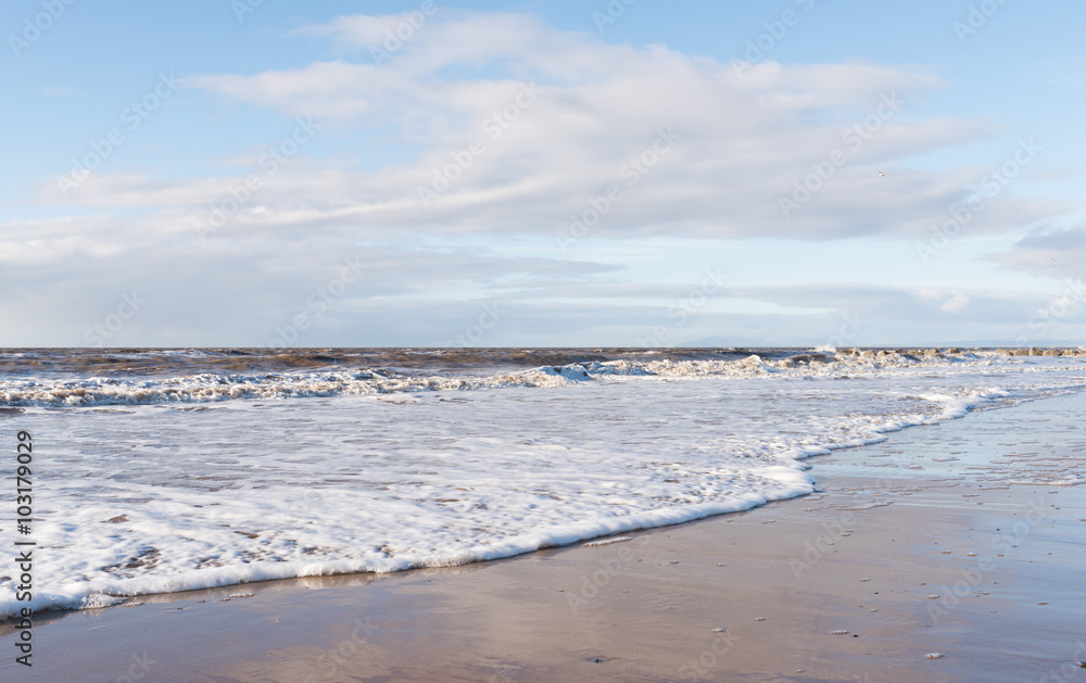 relaxing and gentle calming waves flowing into a beach at sundown