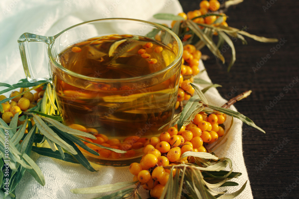 Sea buckthorn tea and branch of a sea buckthorn on a wooden surface. Tea buckthorn Sea buckthorn tea and branch of a sea buckthorn on a wooden surface. Tea buckthorn