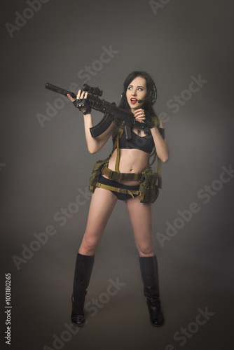 Young brunette in camouflage with a gun © vicusechka89