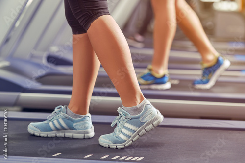 woman's muscular legs on treadmill, closeup