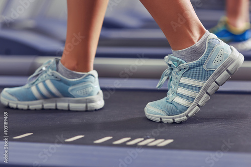 woman s muscular legs on treadmill  closeup