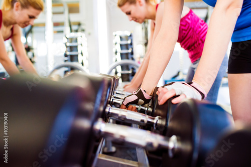 Detail of women in gym working out with weights