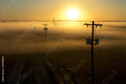 фотографія Telephone poles and farm ranch rural countryside silo on a foggy misty morning a