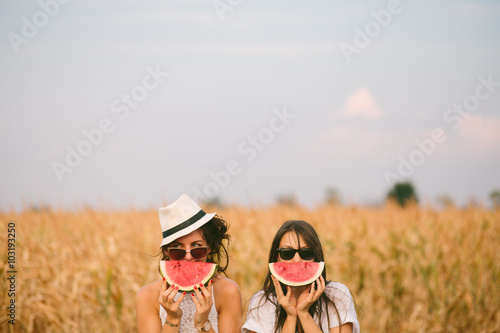 Two young woman holding watermelon

 photo