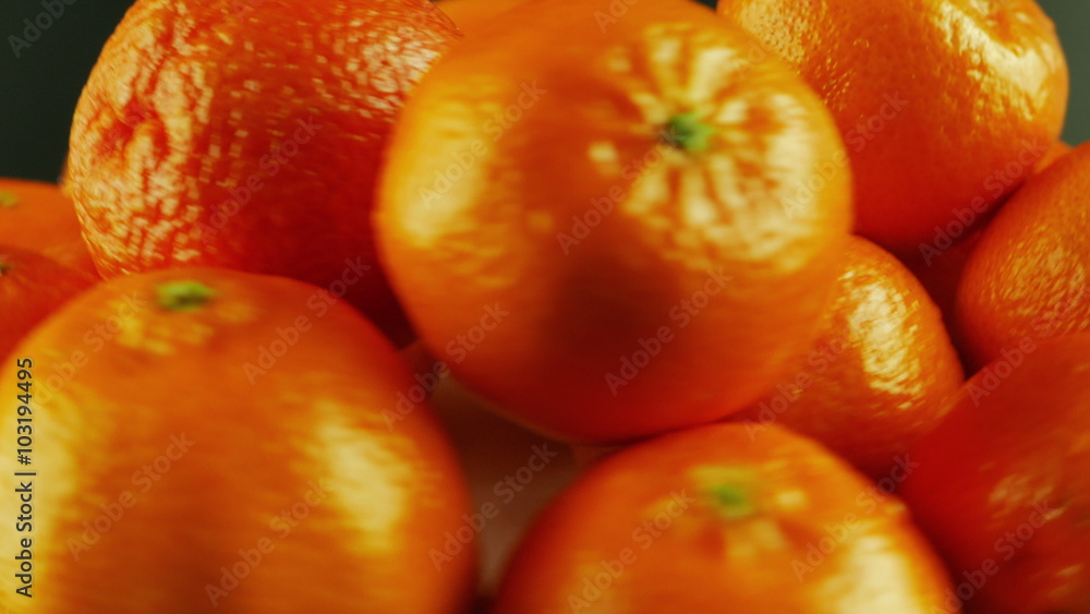 A macro shot of ripe tangerines rotating against a black background.
A macro shot of ripe tangerines rotating against a black background.