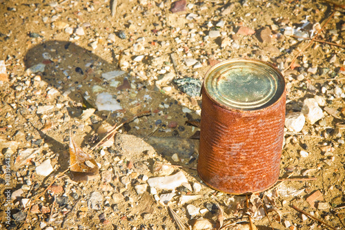 Old rusty jar resting on the ground - image with copy space photo