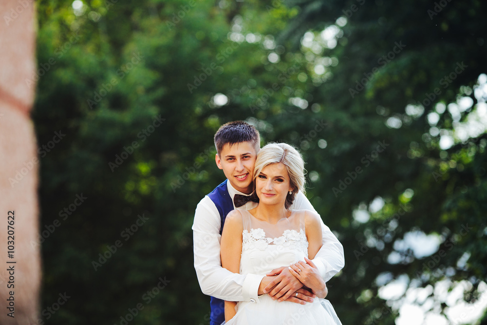 Beautiful wedding couple hugging in the park Beautiful wedding couple hugging in the park