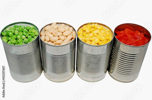 Opened cans of peas, cannellini beans, corn and tomatoes on a white background