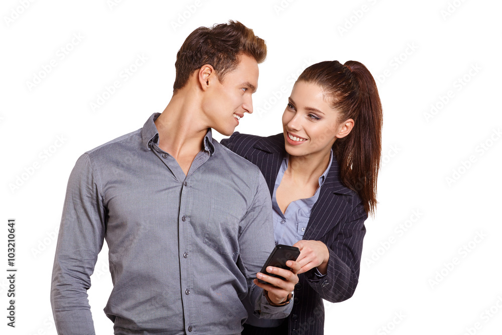 Smiling couple on phone call looking at each other on white screen Smiling couple on phone call looking at each other on white screen