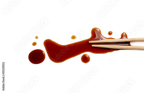 splashes of soy sauce and chopsticks isolated on white. wooden chopsticks dipped in soy sauce spilled. splashes and drops of isolated on white background. flat lay, top view