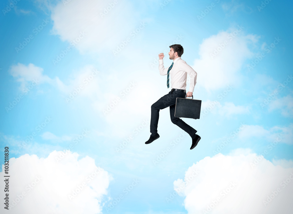 Business person jumping over clouds in the sky Business person jumping over clouds in the sky
