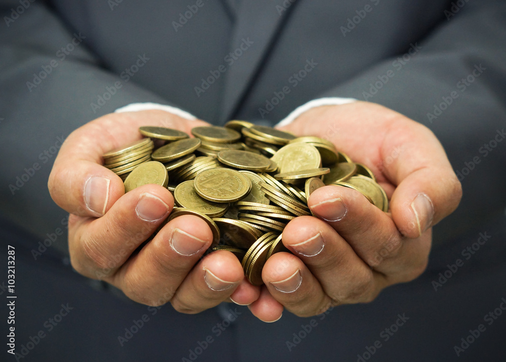 hands of a businessman holding golden coins