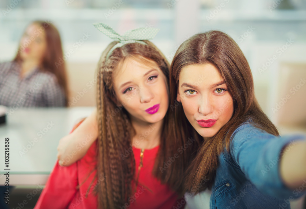 Two girls pouting while taking a selfie photo on mobile phone. Two girls pouting while taking a selfie photo on mobile phone.