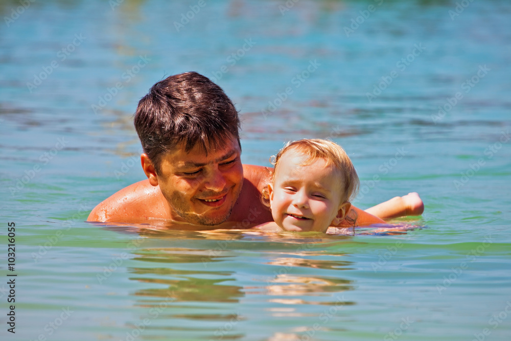 Father and son swimming in the sea