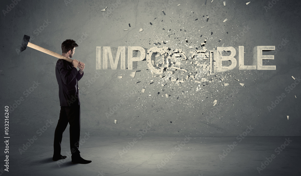 Business man hitting impossible sign with hammer Business man hitting impossible sign with hammer