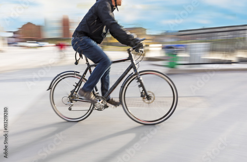 Man riding bike in blurred motion in city landsacpe