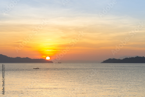 Sunset at the ocean with a little boat © nattapan72