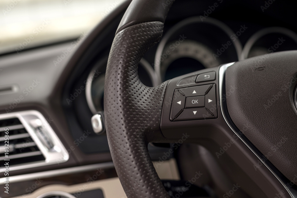 Control buttons on steering wheel. Car interior detail.