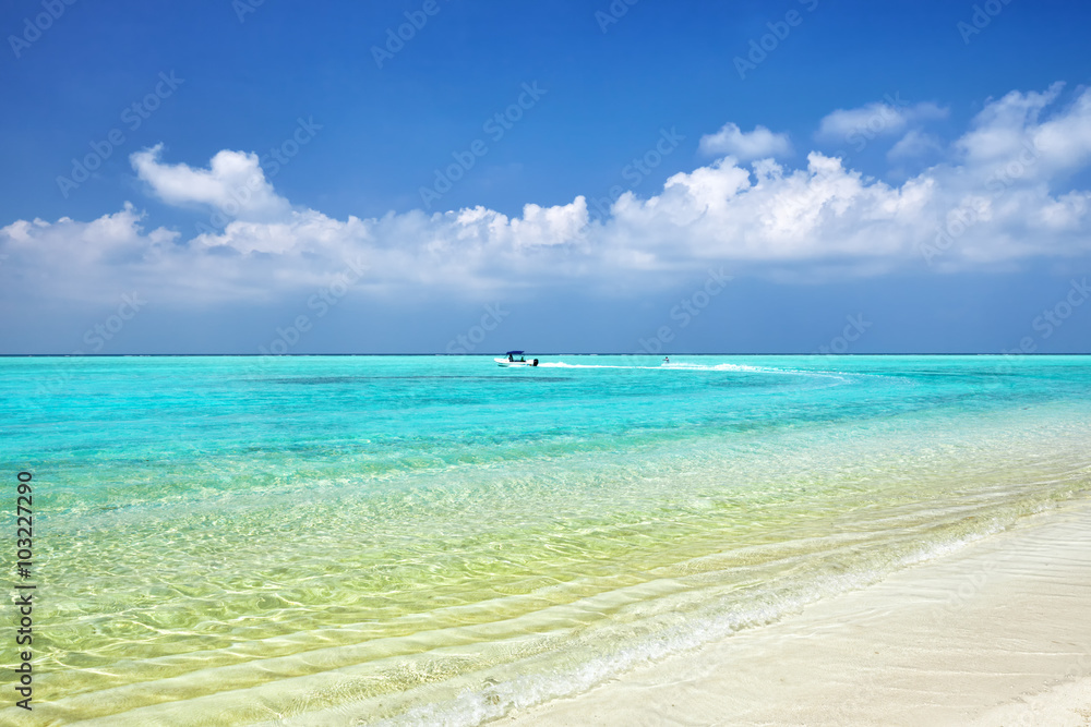 Shoreline of a tropical island with boat in the Maldives and vie